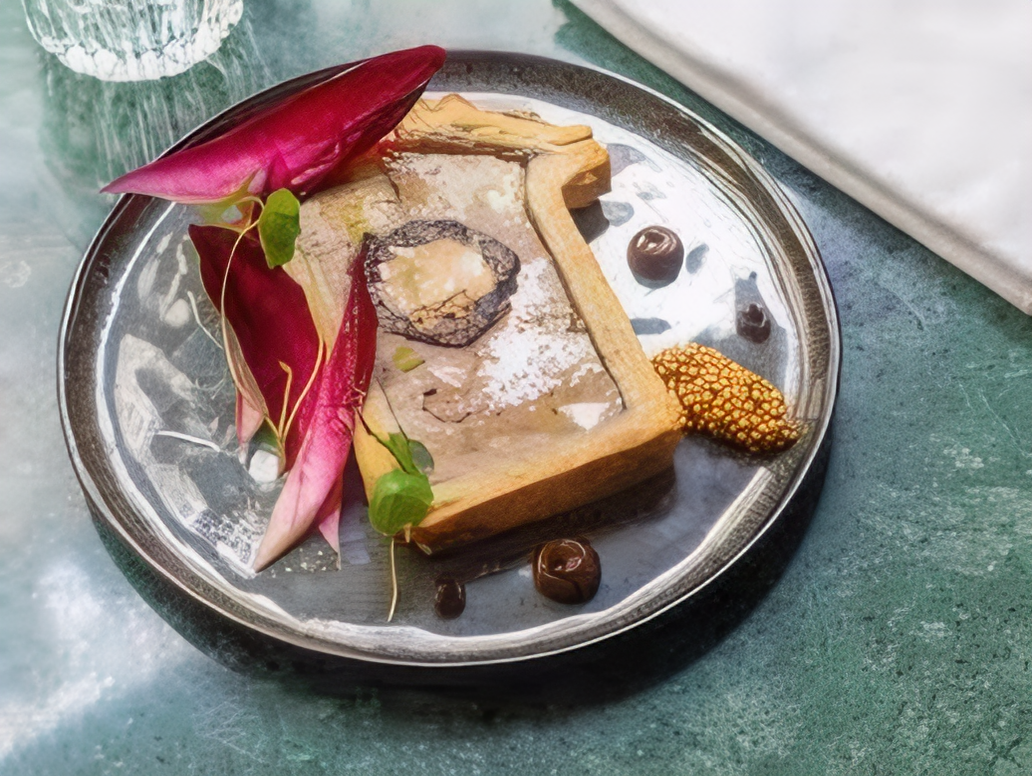 Plat gastronomique avec truffe et décoration florale.