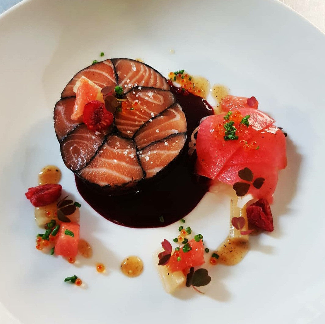Plat de saumon artistiquement présenté avec garnitures.