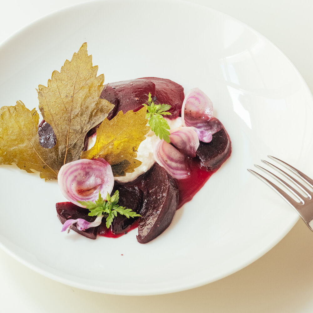 Plat élégant avec betteraves, fromage et feuilles dorées.