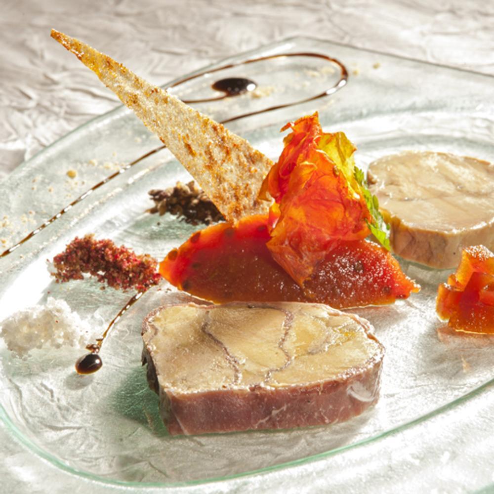 Entrée gastronomique avec foie gras, garnitures colorées et présentation artistique.