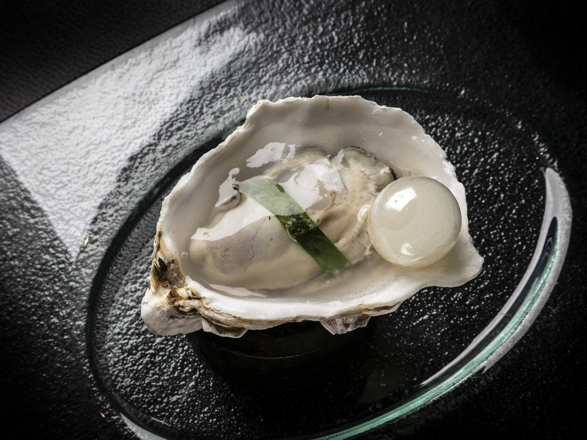 Huître avec perle et garniture verte