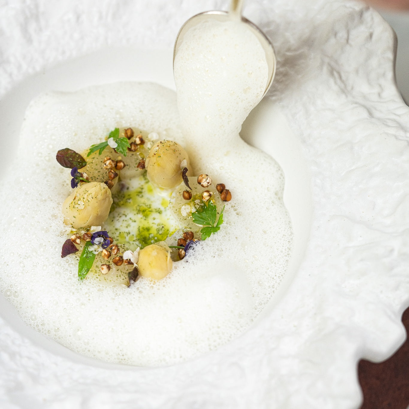 Plat gastronomique avec mousse et garnitures délicates.