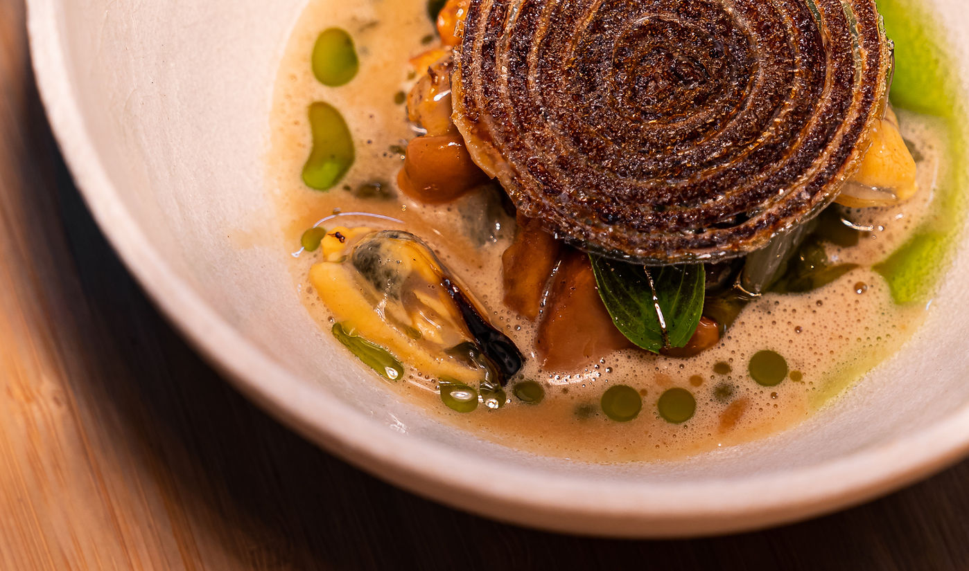 Plat gastronomique avec sauce et herbes fraîches.