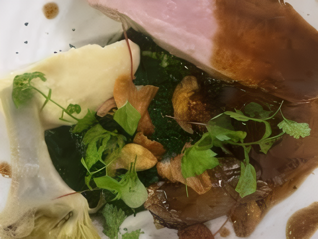 Gros plan d'une assiette gastronomique avec des herbes fraîches et une sauce raffinée pour une présentation élégante.