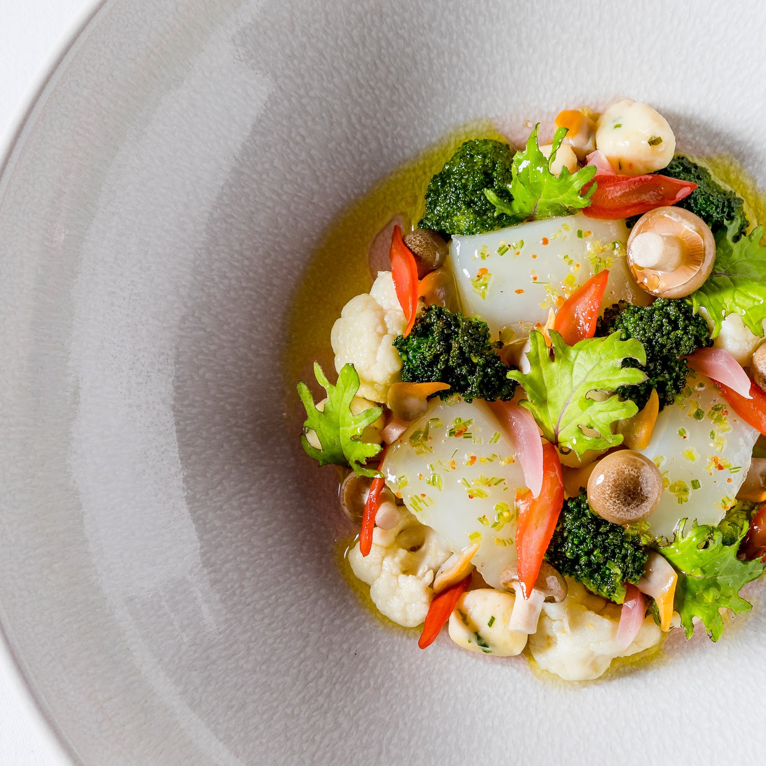 Assiette printanière avec poisson nacré et petits légumes croquants