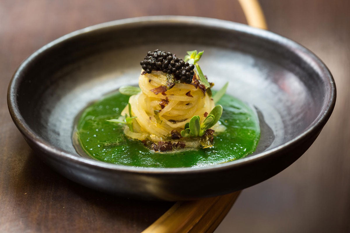 Plat de pâtes avec caviar et sauce verte.