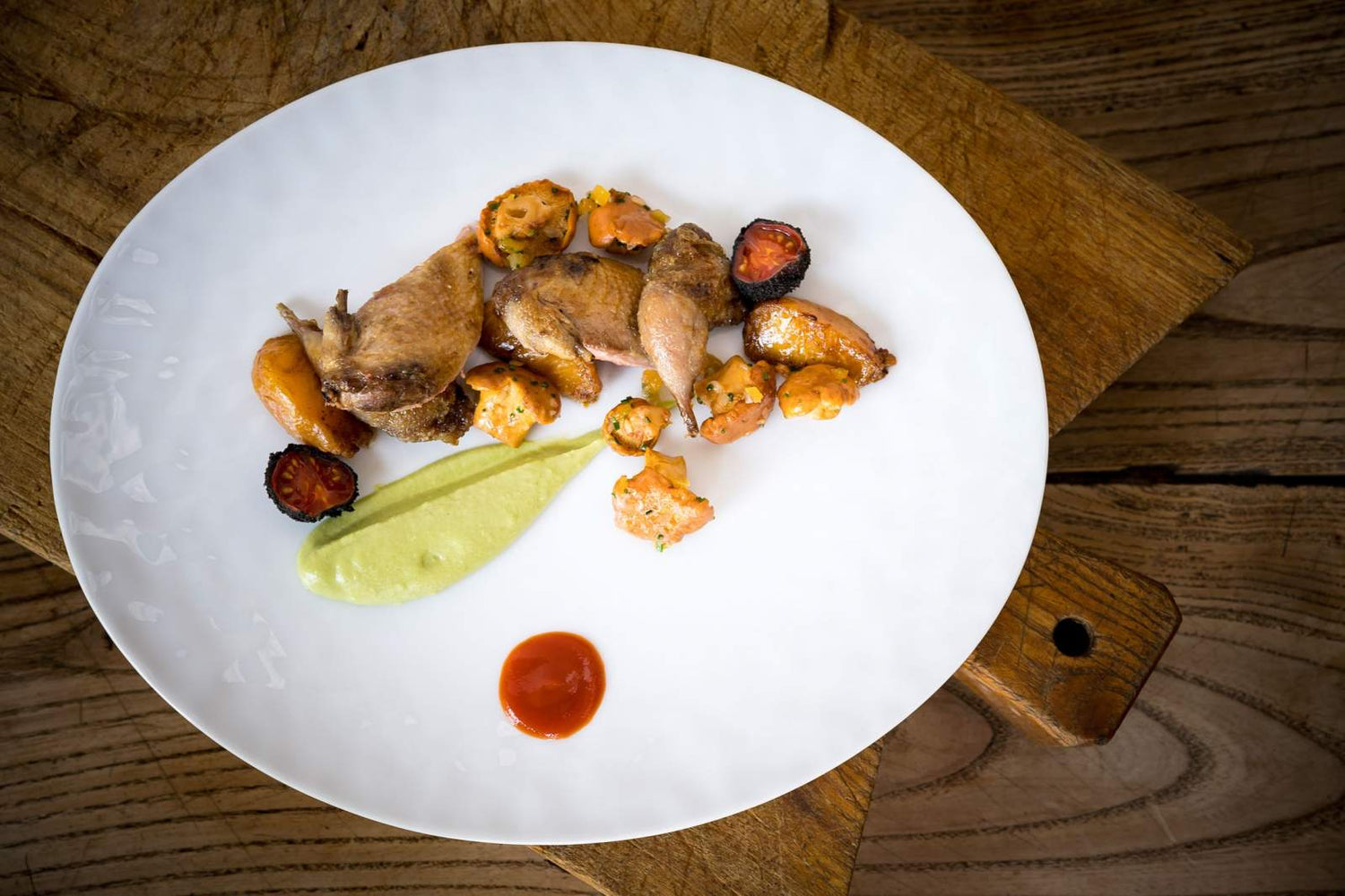 Plat de viande avec des légumes et des sauces colorées.