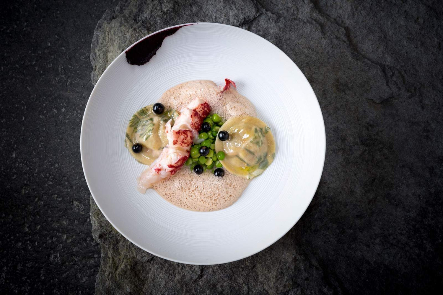 Plat raffiné avec des raviolis, des légumes et des fruits de mer.