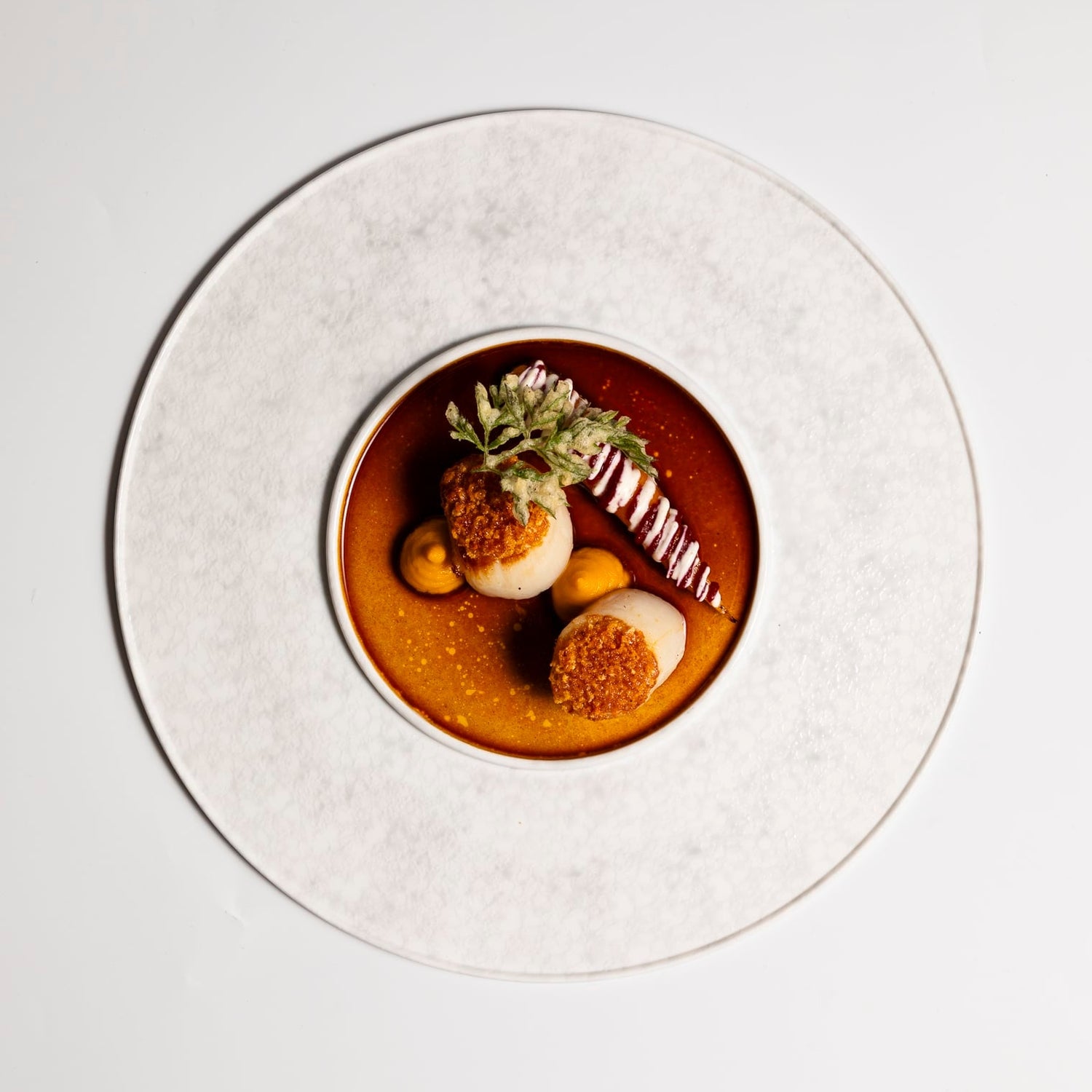 Plat gastronomique avec sauce brune et garnitures.