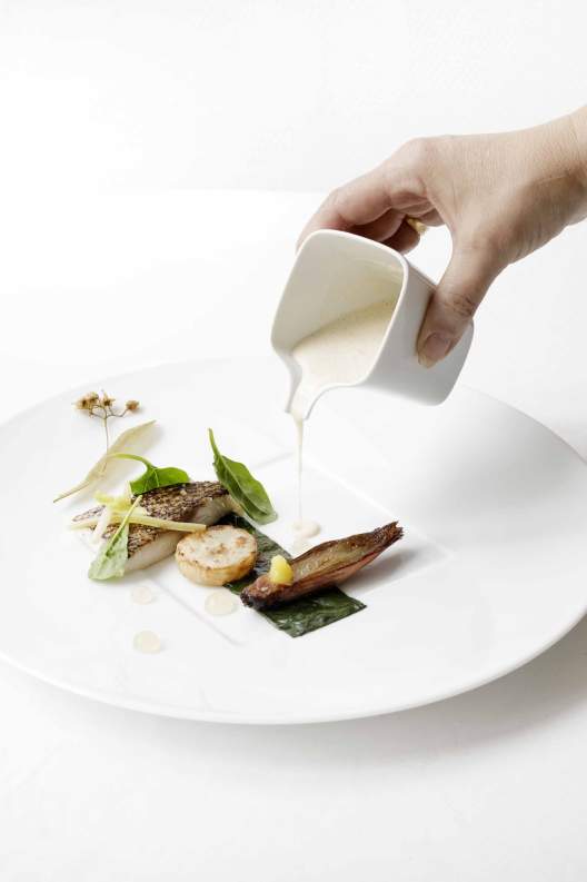 Sauce versée sur un plat gastronomique