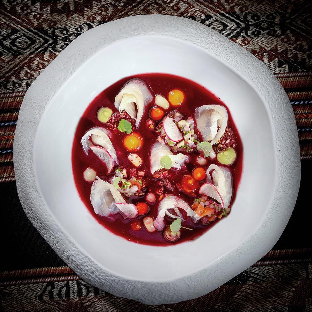 Plat de ceviche avec sauce rouge et garnitures.