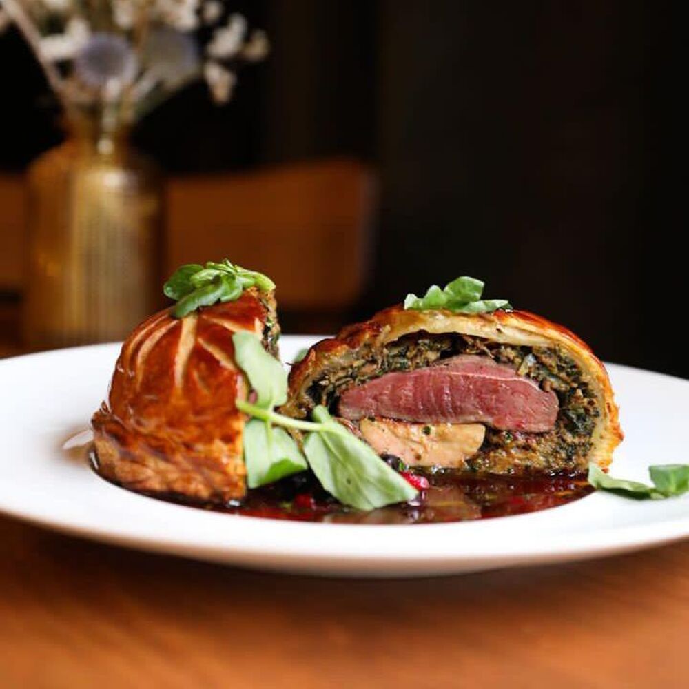 Beef Wellington sliced on a plate with garnish.