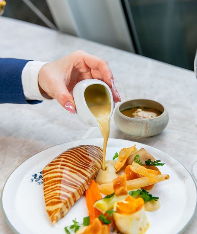 Volaille snackée et recouverte d'une sauce, petites carottes 