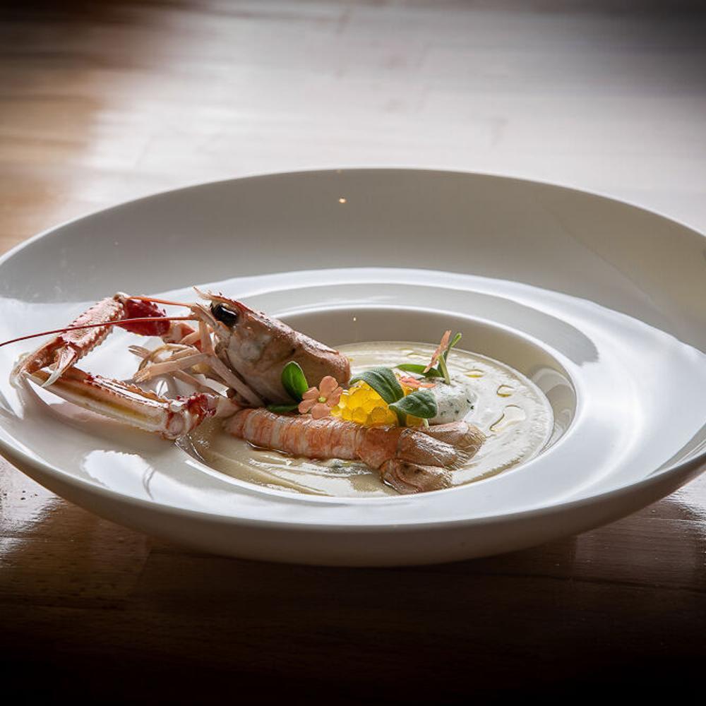 Plat gastronomique avec crustacé et sauce.