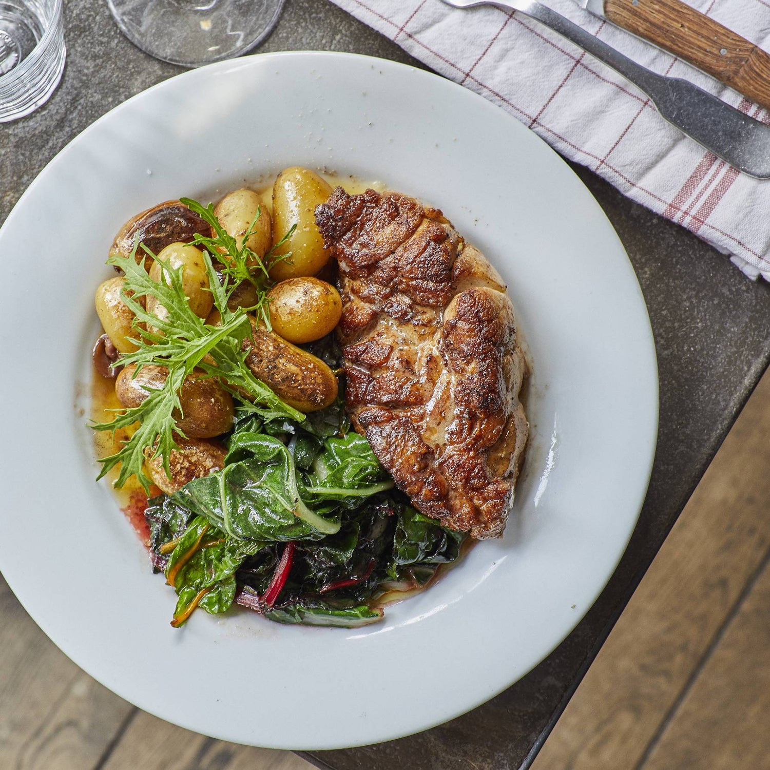 Plat de viande avec pommes de terre et légumes verts.