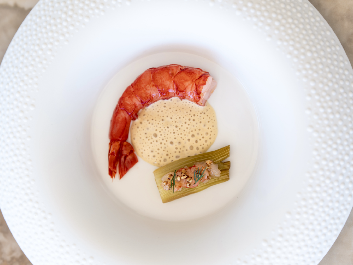 Plat gastronomique avec crevette rouge, sauce émulsionnée et garniture créative