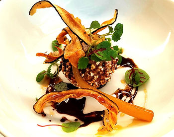 Plat gastronomique avec légumes et sauce.