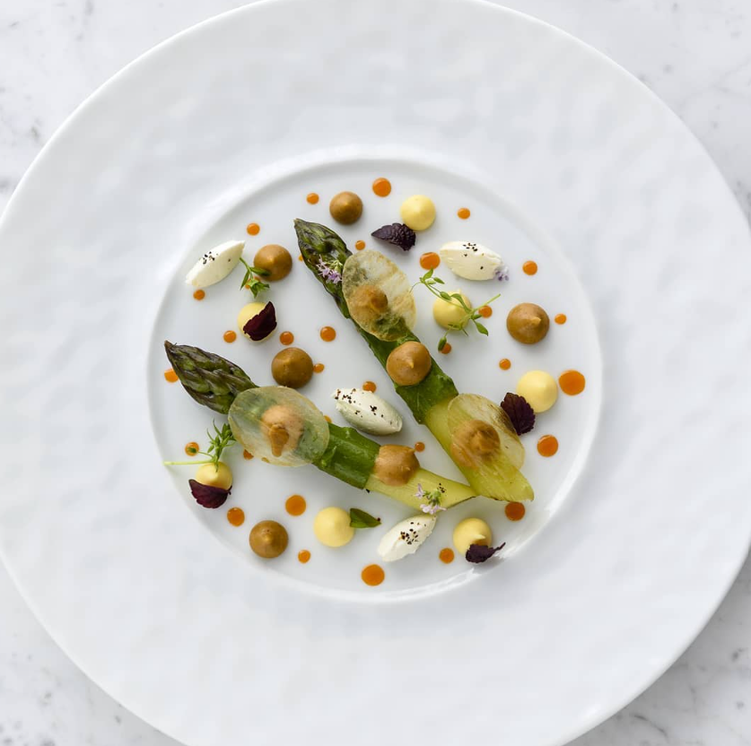 Une assiette gastronomique composée d'un filet de poisson délicatement décoré de légumes frais.