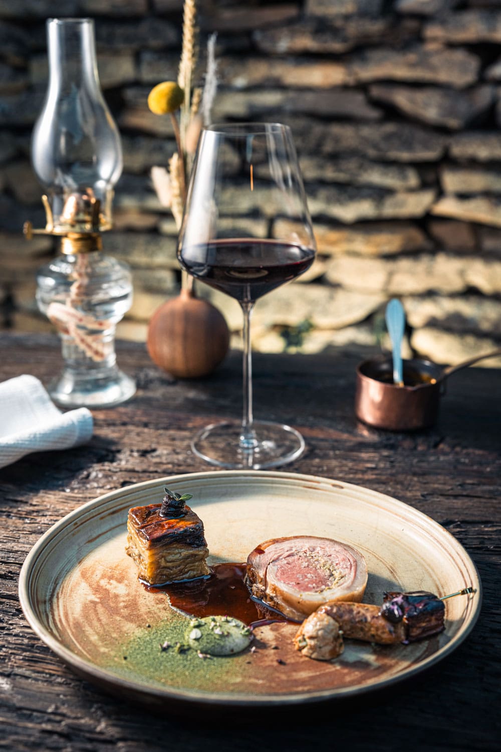 Plat de présentation gastronomique avec une pièce de viande, des légumes et une sauce sur une assiette artistique