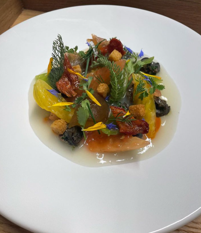 Assiette colorée composée de légumes variés, herbes fraîches et fleurs comestibles.