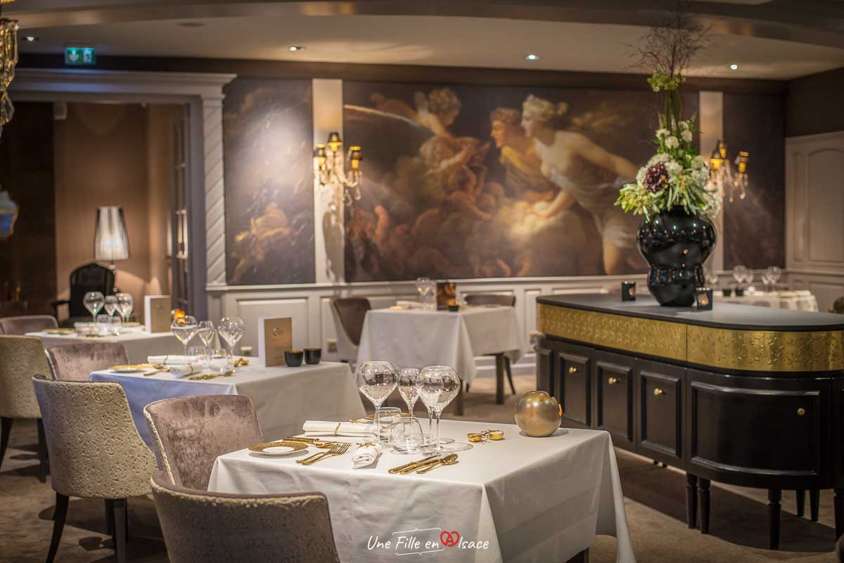 Restaurant élégant avec tables dressées et mur décoratif.