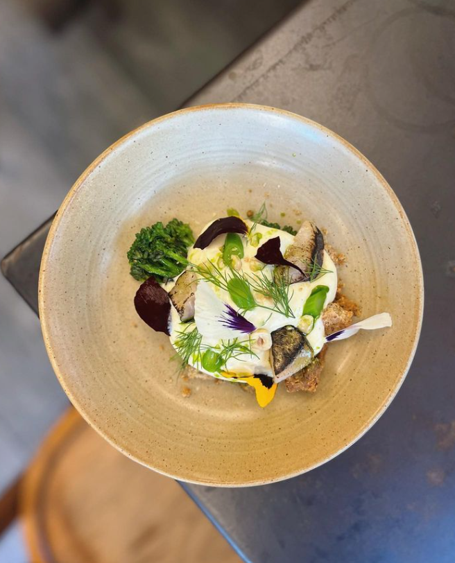 Assiette vue de haut contenant un plat délicatement préparé avec des légumes et des herbes.