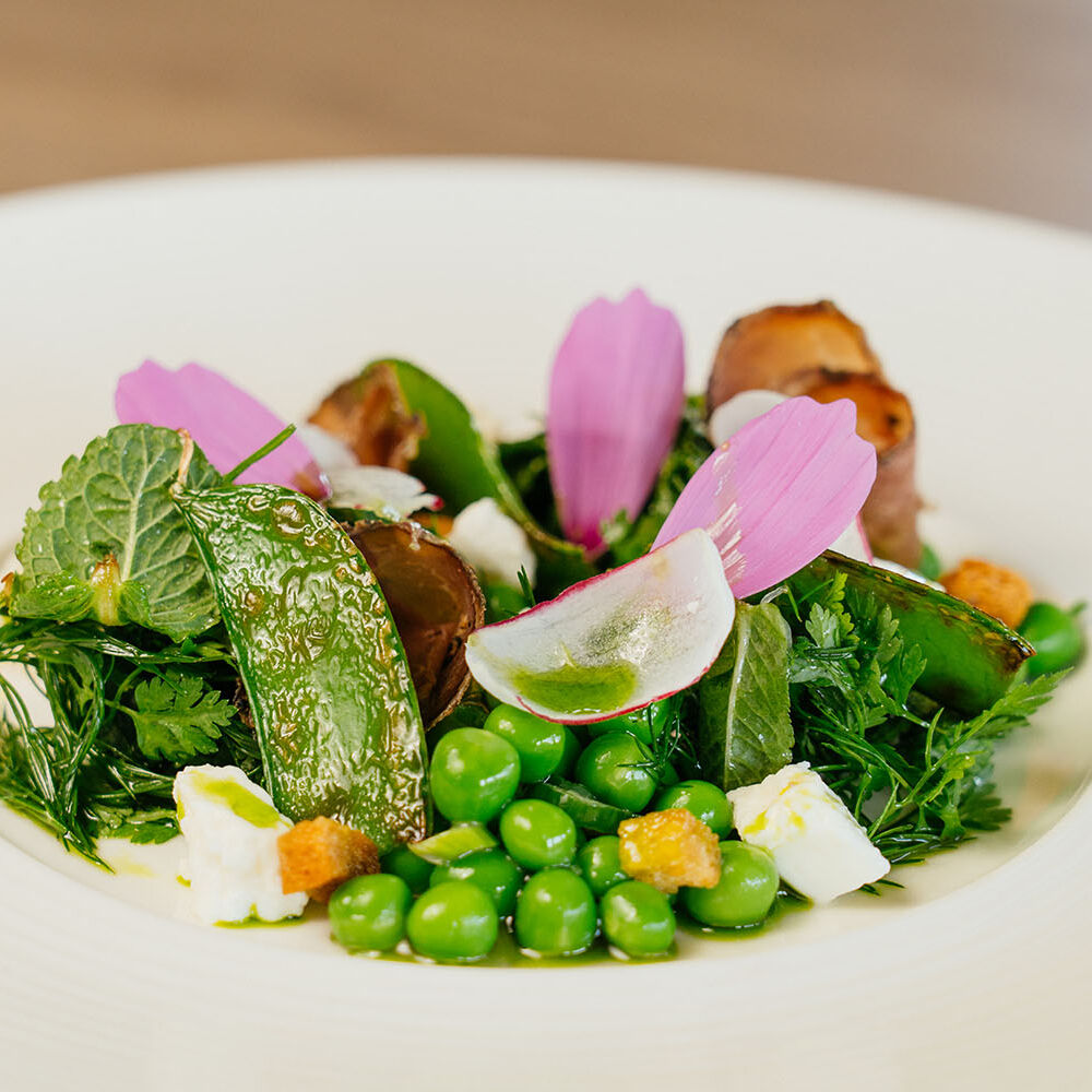 Assiette colorée avec légumes frais et fleurs comestibles.
