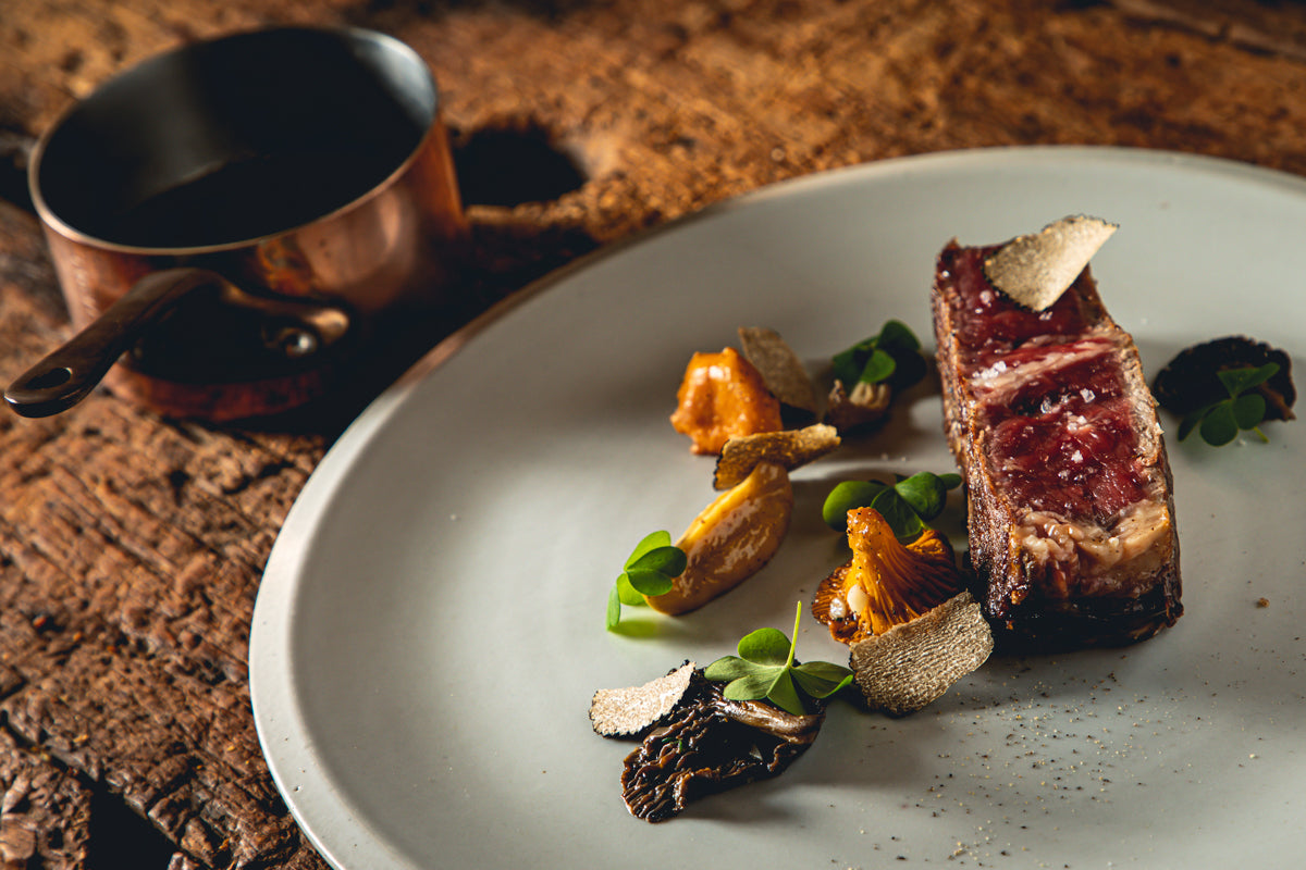 Pièce de bœuf grillée et poêlée de champignons et lamelles de truffe