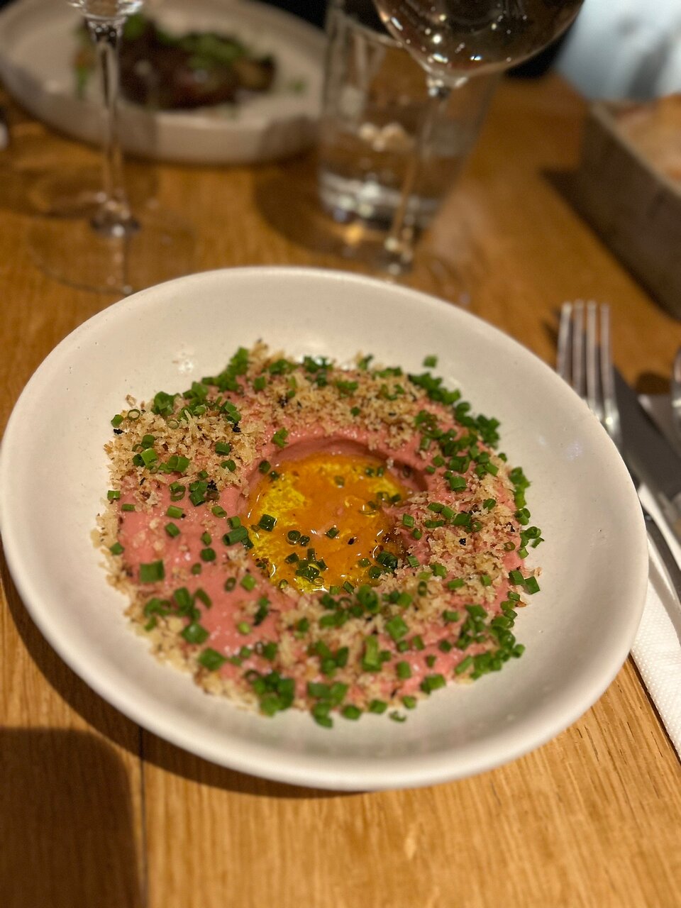 Plat avec tartare et jaune d'œuf au centre.