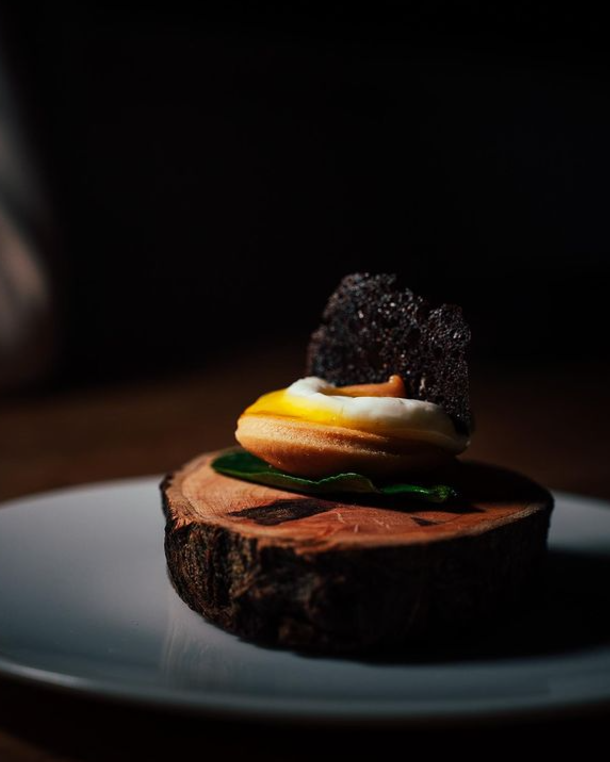 Amuse bouche dressé sur un rondin de bois, sablé, crémeux, tuile croquante